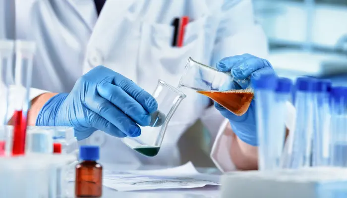 Técnico de laboratorio vertiendo un reactivo en la industria química